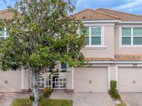 Two-story townhome with attached garage and landscaping at 8311 Foster Dr, Davenport, FL 33896