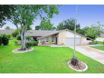 Single-story home with attached two-car garage and lawn at 1889 Seclusion Dr, Port Orange, FL 32128