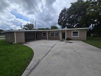 Tan single story home with carport and landscaped yard at 2501 Gulfstream Rd, Orlando, FL 32805