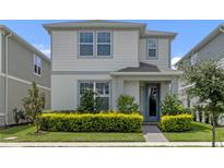 Two-story house with gray siding, a light gray door, and landscaping at 14234 Lanikai Beach Dr, Orlando, FL 32827