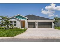 One-story home with two-car garage, light-colored walls, and a teal accent at 1042 Brimstone Cir, Winter Haven, FL 33884