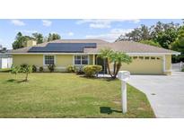 Single-story home with solar panels and a well-maintained lawn at 105 Hainesport Dr, Lake Alfred, FL 33850