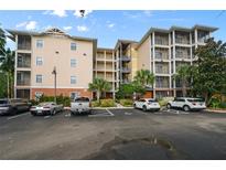 Condo building exterior with ample parking and surrounding landscaping at 3050 Pirates Retreat Ct # 502, Kissimmee, FL 34747