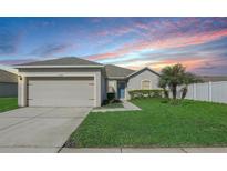 One-story house with a two-car garage and green lawn at 6304 Red Herring Dr, Winter Haven, FL 33881