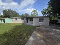 House exterior, featuring a ranch-style home with a grassy yard at 5603 Perrine Dr, Orlando, FL 32808