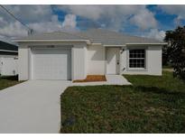 Newly constructed home with a white exterior and a two-car garage at 1138 Avenue E, Haines City, FL 33844