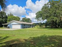 Charming blue home with a large front yard and mature trees at 4810 N Galloway Rd, Lakeland, FL 33810