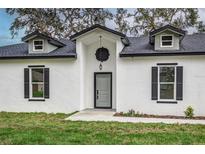 Modern home exterior with gray door and black shutters at 225 Diesel Rd, Mulberry, FL 33860