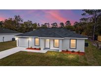 Newly constructed single-Gathering home with a gray roof and landscaping at 13371 Sw 112Th Pl, Dunnellon, FL 34432