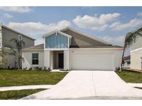 Two-story house with a two car garage and front yard at 1584 Ellesmere Ave, Haines City, FL 33844