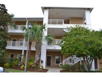 Two-story condo building with palm trees and lush landscaping at 511 Rum Run # 33511, Davenport, FL 33897