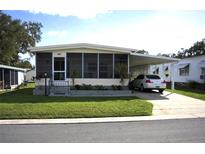 Single-wide manufactured home with carport and landscaped yard at 606 Elizabeth Ln, Lakeland, FL 33809