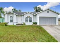 One-story house with gray garage and green lawn at 7713 Manor Dr, Lakeland, FL 33810