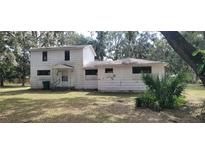 Two-story house needing renovations, featuring a large yard at 242 Oak Hill Rd, Lady Lake, FL 32159