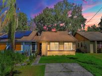 Tan house with brown roof, solar panels, and a small front yard at 1057 Old South Dr, Lakeland, FL 33811