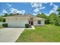 One-story house with attached garage and grassy yard at 1421 Teal Ct, Kissimmee, FL 34759