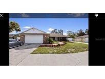 Brick home with a well-maintained lawn, driveway, and garage at 534 Holloway Shores Dr, Lakeland, FL 33801