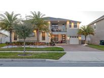 Two-story home with modern design, palm trees, and a landscaped yard at 2436 Chateau Loop, Kissimmee, FL 34741