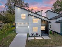 Modern two-story house with white siding and a dark gray accent wall, a landscaped yard and driveway at 716 W 14Th St, Lakeland, FL 33805
