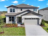 Two-story house with a neutral color scheme and a two-car garage at 1053 Silverlake Blvd, Lake Alfred, FL 33850