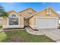 Attractive single-story home with a two-car garage and well-manicured lawn at 2622 Montego Bay Blvd, Kissimmee, FL 34746