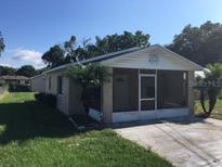 Tan single story home with screened porch and landscaped yard at 2408 E Magnolia St, Lakeland, FL 33801