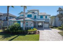 Two-story home with gray siding, blue shutters, and a paver driveway at 9406 Dugard Ct, Orlando, FL 32827