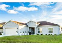 Newly built home with a two-car garage and well-manicured lawn at 480 Britten Drive, Poinciana, FL 34758