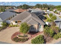 Single-story home with landscaped yard and driveway, located in a residential neighborhood at 1049 Carver Ct, The Villages, FL 32163