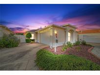 Evening view of charming villa with landscaped yard and attached garage at 17090 Se 76Th Caledonia Ter, The Villages, FL 32162