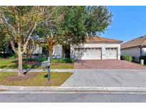 Single-Gathering home with a three-car garage and brick paver driveway at 1369 Palmetto Dunes St, Davenport, FL 33896