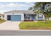 Charming single-story home with a blue garage door, landscaped yard, and welcoming curb appeal at 1074 Canary S Cir, Lakeland, FL 33809