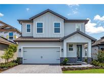 Charming two-story home with a light blue and gray exterior, attached garage, and landscaped yard at 7849 Somersworth Dr, Kissimmee, FL 34747