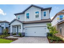 Charming two-story home with a light blue exterior, paved driveway, and attached garage at 7853 Somersworth Dr, Kissimmee, FL 34747