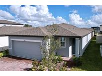 One-story home with gray exterior, brick paver driveway, and attached garage at 4407 Rapallo Ave, Winter Haven, FL 33884