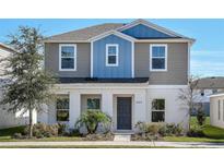 Two-story house with gray and blue siding, landscaping, and a gray front door at 1552 Hummingbird Rd, Winter Haven, FL 33884