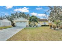 Cute yellow house with a large yard and a two-car garage at 136 Cory Ct, Auburndale, FL 33823