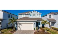 Two-story house with light blue siding, white garage door, and palm trees at 1166 Aloha Blvd, Davenport, FL 33897