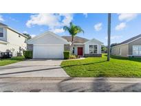 Single-story home with two car garage and well-maintained lawn at 745 Jaybee Ave, Davenport, FL 33897