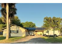 House exterior with solar panels and a large driveway at 748 Merrimac Dr, Port Orange, FL 32127