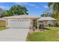 Tan house with a two-car garage and landscaped yard at 2739 Everleth Dr, Lakeland, FL 33810