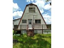 A-frame house with a wooden deck and stairs at 11390 E Irlo Bronson Memorial Hwy, St Cloud, FL 34773