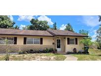 Ranch-style home with brown roof, stone facade, and landscaped yard at 9 Villa Villar Ct, Deland, FL 32724