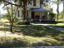 Two-story house exterior with porch and large trees at 207 E 2Nd Ave, Pierson, FL 32180