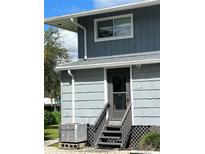 Exterior view of a building with gray siding and stairs at 2329 River Ridge Rd # 160, Deland, FL 32720