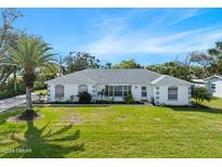 Single-story home with white exterior and green lawn at 36 Dresden Cir, Ormond Beach, FL 32174