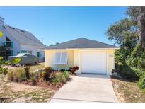 Cute yellow house with a white garage door and well-manicured landscaping at 134 Avalon Dr # A, Ormond Beach, FL 32176