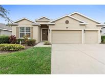 Tan house with two-car garage and manicured lawn at 509 W Victoria Trails Blvd, Deland, FL 32724