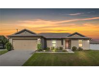 House exterior at dusk, two-car garage, landscaped lawn at 3171 Utah Dr, Deltona, FL 32738