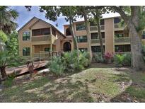 Two-story condo building with balconies and lush landscaping at 1401 S Palmetto Ave # 402, Daytona Beach, FL 32114